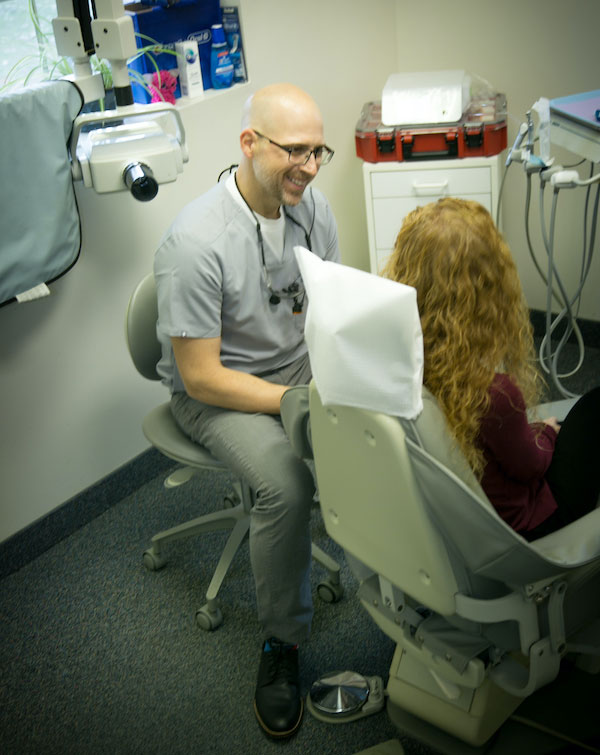 Dr. Brian Bialy of Castle Family Dentistry talking with a patient in the dental chair