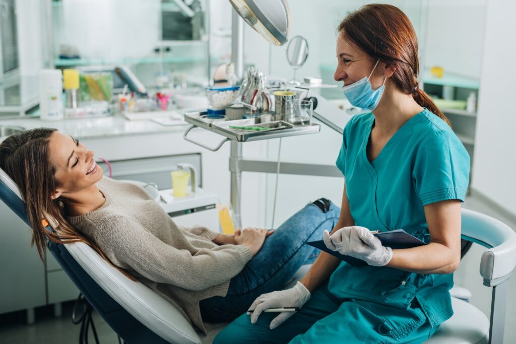 female patient and a female hygienist smiling at one another
